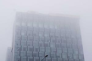 Ceața în București. Vizibilitate redusă la marginea capitalei. Cladire acoperită de o ceată deasă.