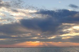 Soarele acoperit de nori în încercarea sa de a mângâia apa din Golful Musura.